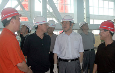 图为辽宁省水利厅厅长仲刚（左二）与集团公司董事长周世祥（右二）在TBM组装调试车间视察。